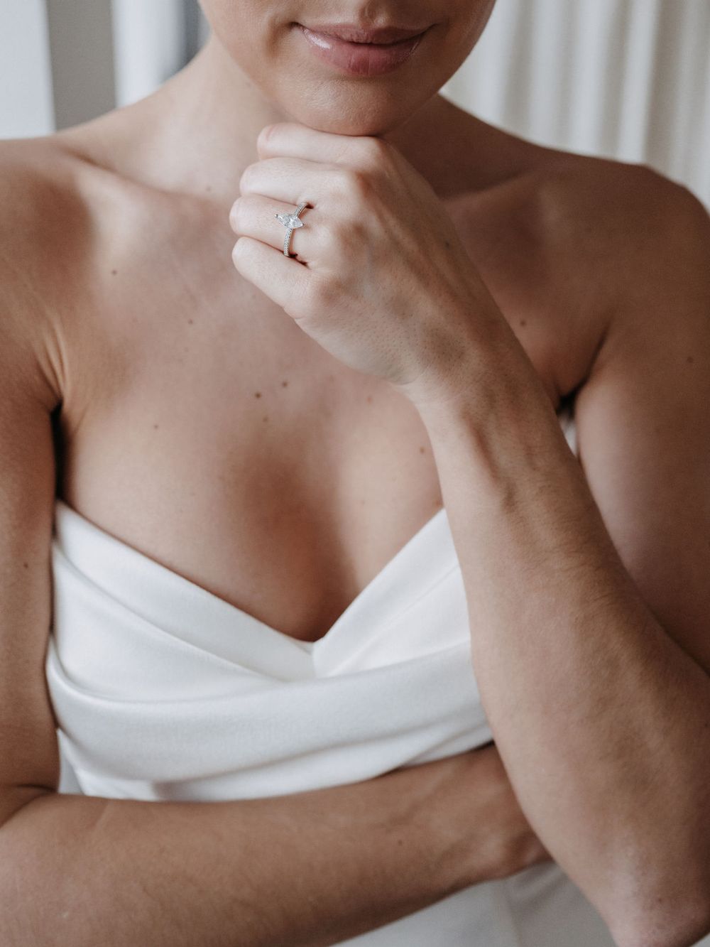 Braut mit Verlobungsring, Hand am Kinn