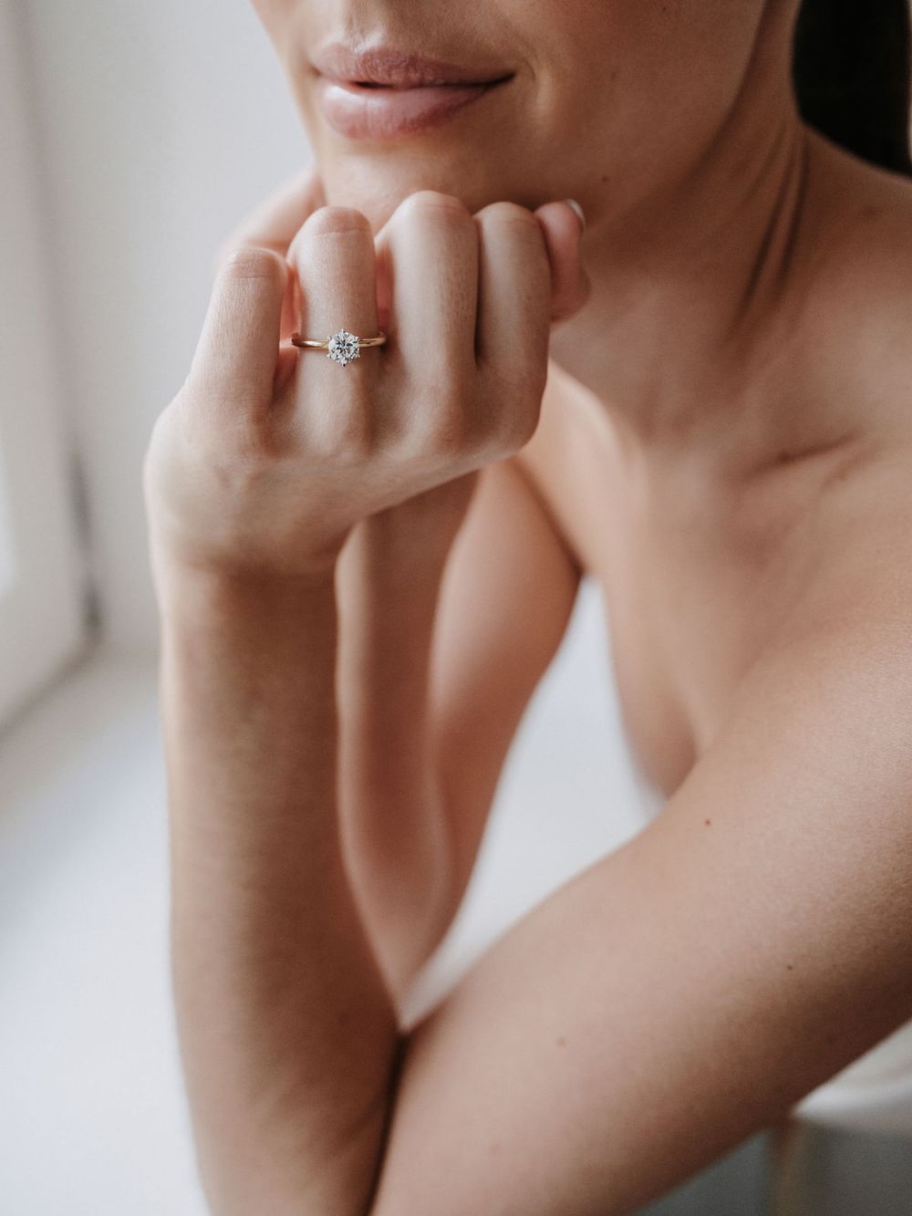 Verlobungsring am Finger, Hand am Kinn