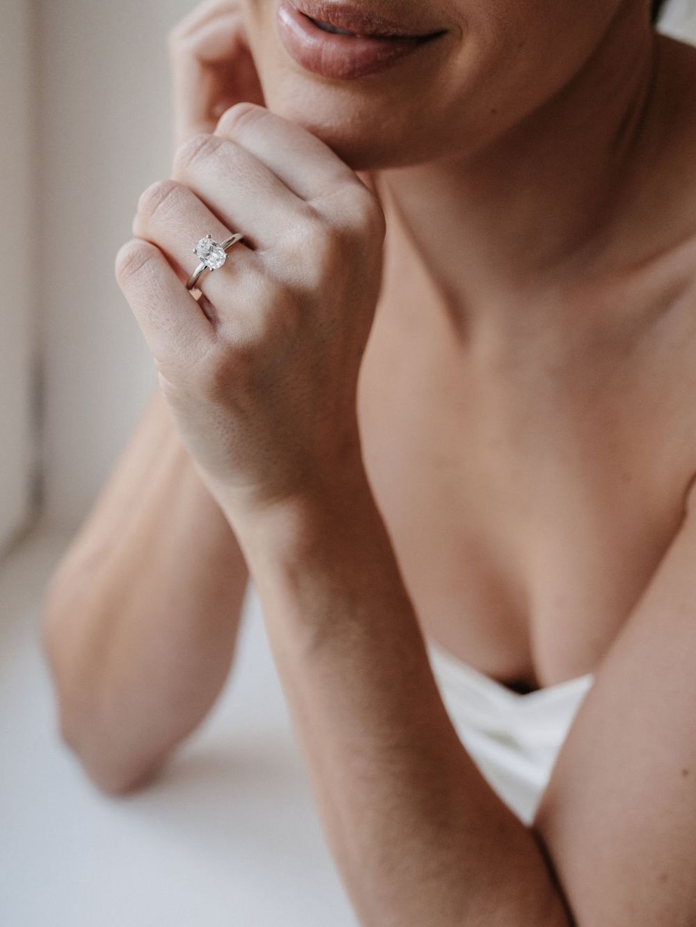Braut mit Verlobungsring, Hand am Kinn