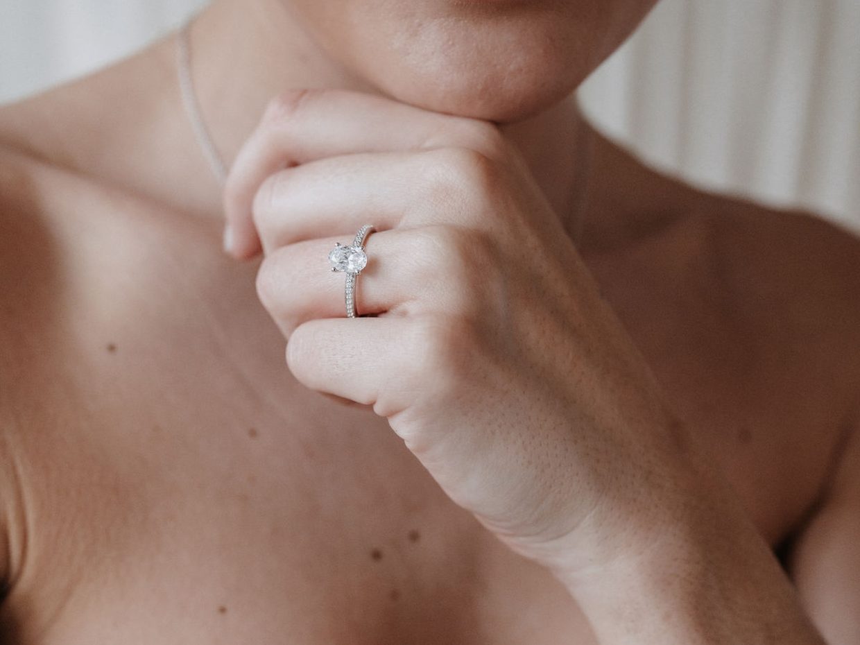 Braut mit Verlobungsring, Hand am Kinn
