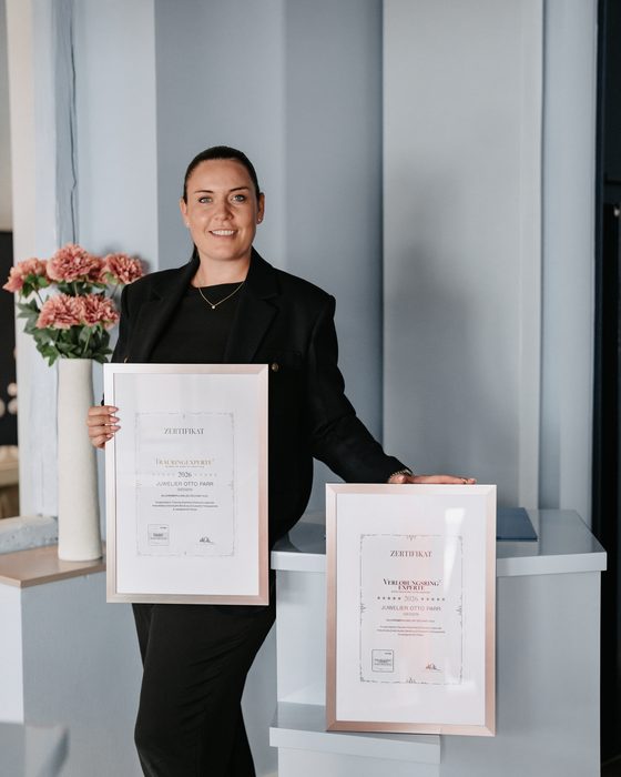 Luisa Parr mit den beiden gerahmten Urkunden Trauringexperte und Verlobungsring-Experte 2026
