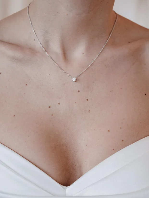 Feine Halskette mit einzelnem Brillant-Anhänger am Dekolleté — Schmuck bei Juwelier Otto Parr in Gießen