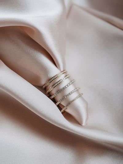 Drei schmale Ringe mit Brillantreihe auf hellem Satin