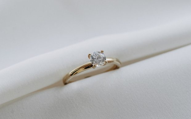 Verlobungsring aus Gelbgold mit Solitär-Brillanten auf weißem Satin
